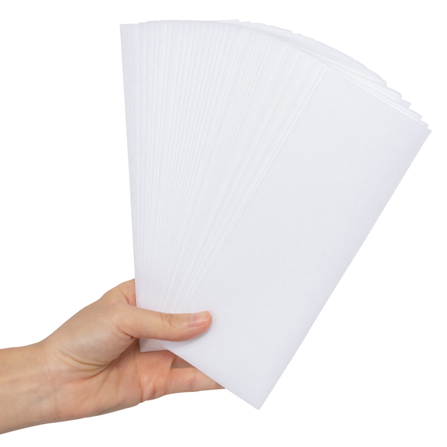 Hand holding stack of white medical-grade nonwoven sheets – cleanroom lab supply photography in Toronto for healthcare product marketing